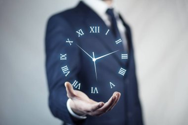 Saat simgesi üzerinde el ile iş adamı 