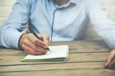 Not Defteri'nde ahşap masaüstünde yazma işadamı