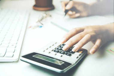 Resepsiyon El Not defteri, hesap makinesi ve klavye çalışan kadın 