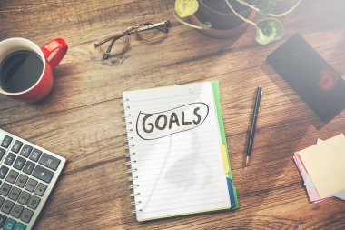 ahşap masa üzerinde sabit ile not defteri hedefleri metin