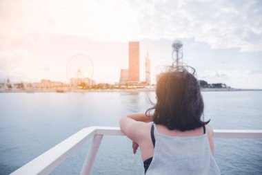 Bir yolcu gemisinde korkulukların yanında duran kadın