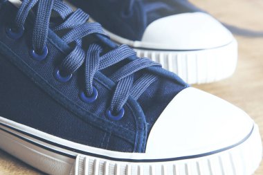 Ahşap masada bir çift spor ayakkabı.