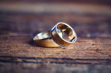 Ahşap masada altın alyanslar.