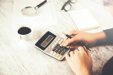 kadın el hesap makinesi ile belge ve kahve.