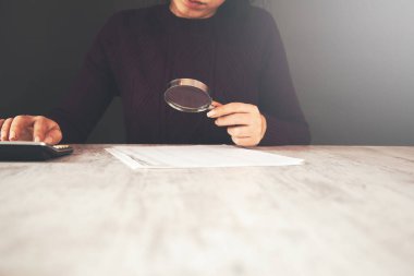 kadın el dokümanı büyüteç ve hesap makinesiyle