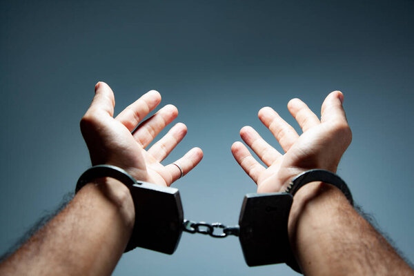 man hand handcuffs on gray background