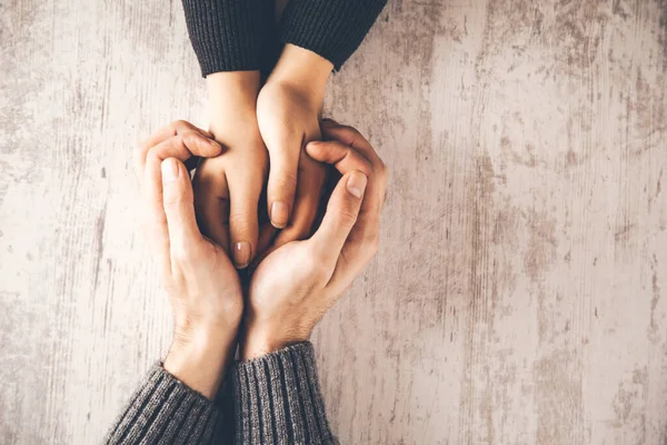 man and woman hands on table