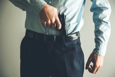 Erkek eli silahı pantolona sokar. 