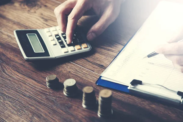 Stock image man hand document with  coins and calculator