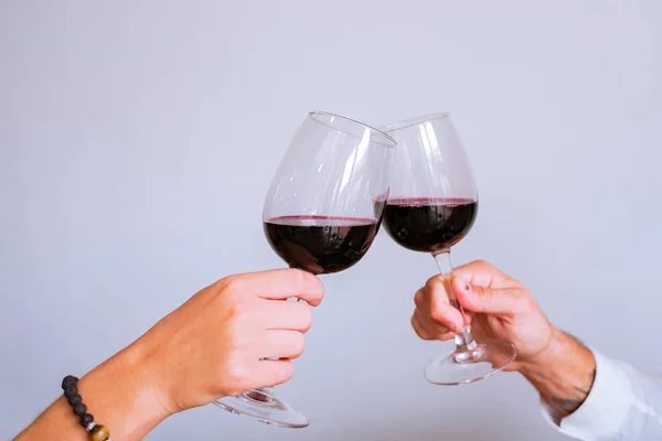 Amantes com copos de vinho no restaurante para o dia do amor. Saúde! Mãos segurando copo de vinho. Fundo cinzento. Celebração, conceito de casamento. Imagem — Fotografia de Stock