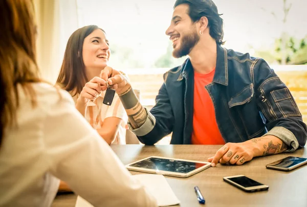Yeni arabanın anahtarına sahip mutlu bir çift. Çift bir arabanın anahtarına sahip. Sözleşmeyi Ajan Kiralık Araba yapıyor. Anahtarlığa odaklan - Resim