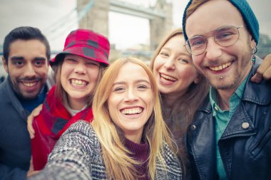 Kafkasyalı mutlu arkadaşlar selfie çekiyor. Öğrenciler teknoloji trendleriyle eğleniyor. Gençlik, teknoloji ve arkadaşlık kavramı - Kıza odaklan.