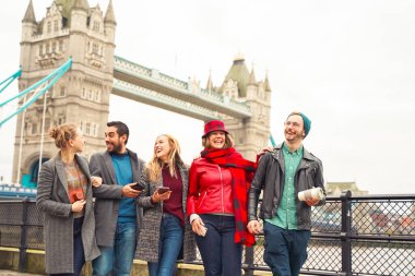 Bir grup iyi arkadaş şehir caddesinde eğleniyor. Bir grup öğrenci birlikte şehir parkında yürüyor, köprünün yakınında. Seyahat ve arkadaşlık kavramı - Görüntü