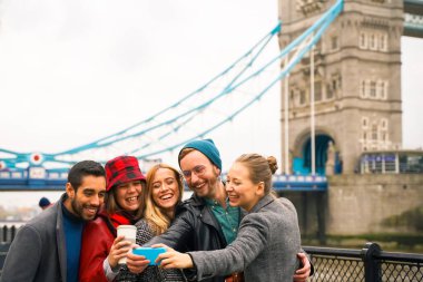 Şehir turunun tadını çıkaran bir grup turist. Bir grup arkadaş Londra 'da selfie çekiyorlar. Üç kız ve iki erkek, kucaklaşıyorlar ve birlikte eğleniyorlar. Seyahat ve arkadaşlık kavramı.