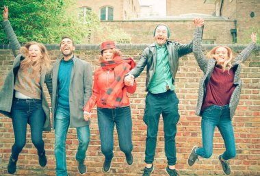 Mutluluk, özgürlük, hareket, çeşitlilik ve insanlar konsepti. Gülümseyen kadın ve erkeklerden oluşan beyaz bir grup atlıyor. Mutlu milenyum dostları kutlama için dışarı atlıyor.