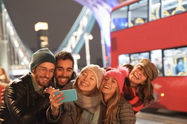 Bir grup iyi arkadaş şehir caddesinde eğleniyor. Büyük köprüde fotoğraf çeken ve selfie çeken bir grup öğrenci. Seyahat ve arkadaşlık kavramı - Görüntü
