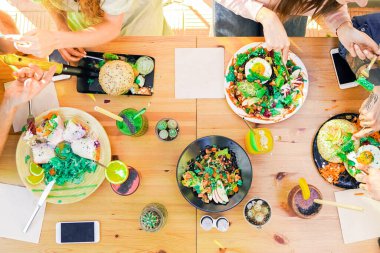 Vejetaryen yemeklerinin en üst görüntüsü, bardaki renkli meyve suyu kasesi. Erasmus öğrencileri vejetaryen ve vejetaryen restoranlarında sohbet edip yemek yiyorlar - yiyecek, içecek ve dostça bir konsept - masaya odaklan.