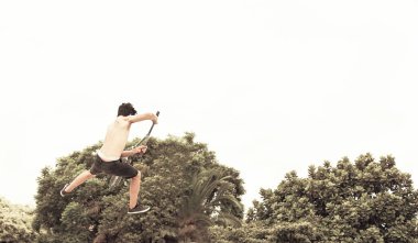 Kaykaycı çocuk kaykay parkında pratik yapıyor. Tekme scooterıyla atlayan bir kaykaycı çocuk. Motorsikletle yaz tatilinin tadını çıkar. Eğlence ve formda kalmak için kaykay yapıyorum. Gençlik yaşam tarzı ve yaz konsepti.