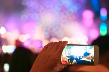 Konser sırasında akıllı telefonla video kaydını kapat. Konserde renkli kalabalık, disko gecesi. Resim