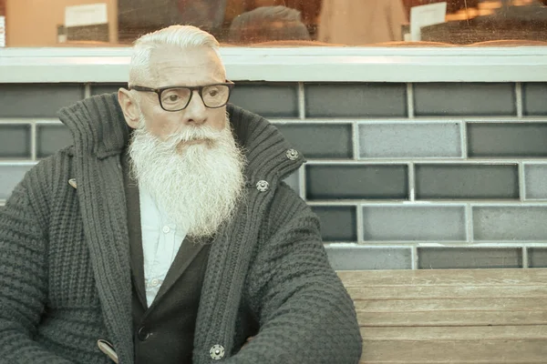 Handsome businessman is sitting in the bar restaurant outside,  Good-looking caucasian man with brooding look sitting in cafe outside waiting his woman - Image.