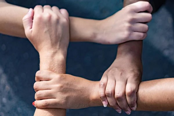 ラテン系 アジア系の手を持つ多人種間の人々がお互いに手首を握っている ユニットと多民族チームでのコード チームワーク 反人種差別の概念 — ストック写真