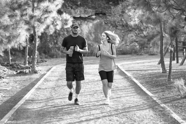 Young people running outdoors. Friends running in the park. Black and white picture. Jogging, healthy lifestyle and sport concept.  Image.