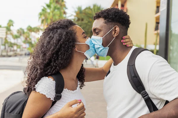 Genç çift Coronavirus salgını sırasında yüz maskesi takarken öpüşüyor. İlişki ve Covid 19 konsepti. Resim