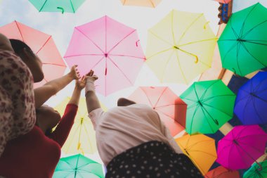 İlk uçuşun hayalini kuruyorum. Uçar gibi yapan kızlar, gökyüzüne dokunun. Çok renkli şemsiyeli kadınlar. Rüya ve aşk konsepti. Odaklanmamış resim