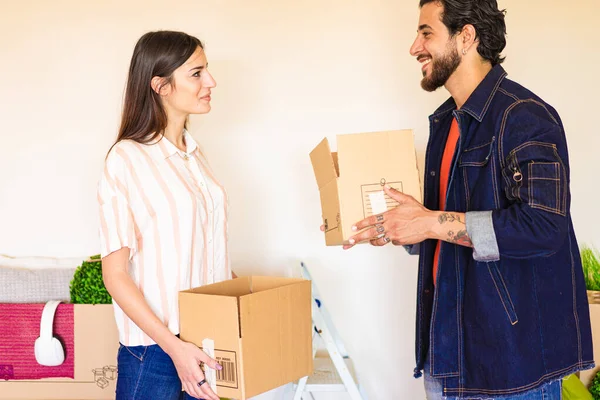 Happy young couple moving in new property house. Workers with happy feelings holding boxes in the new office. Rent, buy apartment and lifestyle concept.