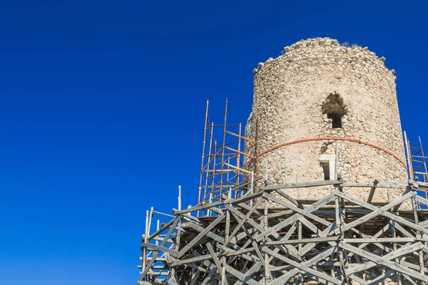 Old stone tower under reconstruction. Repair scaffolding — Stock Photo, Image