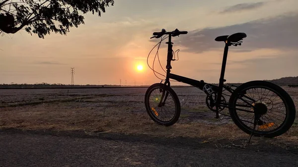Günbatımı arkaplanlı katlanan bisiklet