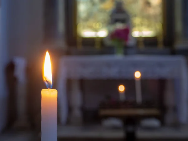 La llama de una vela con el altar de la iglesia en el fondo — Foto de Stock