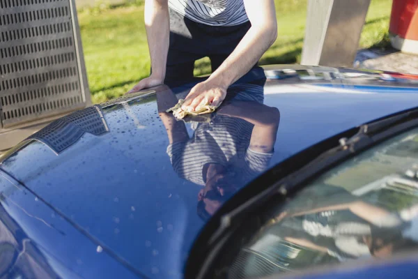 Man drying car with microfiber cloth outdoor