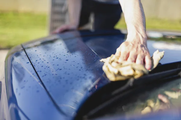 Cropped view of man drying car with microfiber cloth