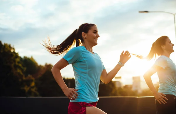 Two female runners racing over the bridge