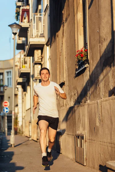 Professional male athlete running on the city street