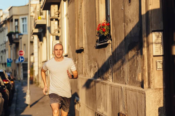 Professional male athlete running on the city street