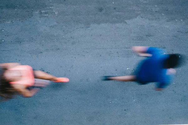 Professional athletes running down alleyway, blurred motion