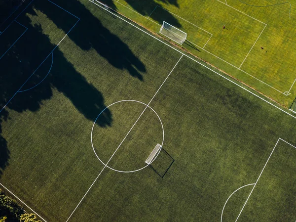 Aerial view of green soccer pitch in sunset light
