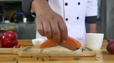 Gurme chef yakın çekim veya Şarküteri parça somon taze yığın deniz tuzu ile balık ve baharatlı biber topraklanmış baharat yemek