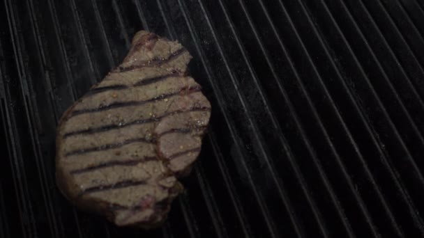 厨师用金属钳把未煮熟的肉放在热腾腾的烤炉上 炉底生火 — 图库视频影像