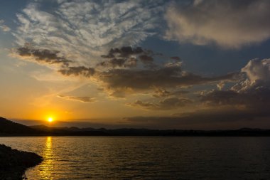 Bulutlu bir gölde gün batımı