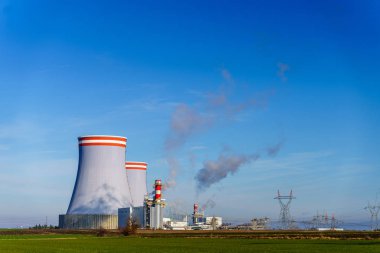 Power station in field under blue sky