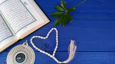 Kutsal Kur 'an ve ahşap arka planda tespih. Ramazan teması