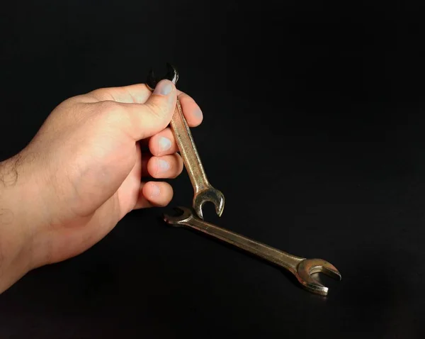 Hand holding wrenches on black background. engineering concept — Stock Photo, Image