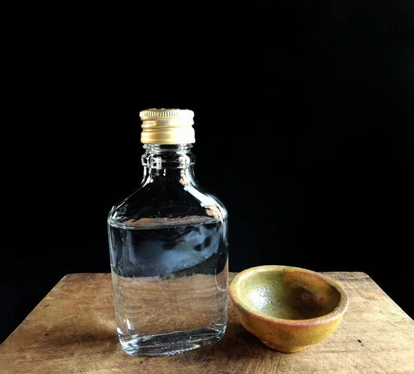 Botella de brandy con taza de barro sobre fondo negro. bebida alcohólica típica de Guatemala — Foto de Stock