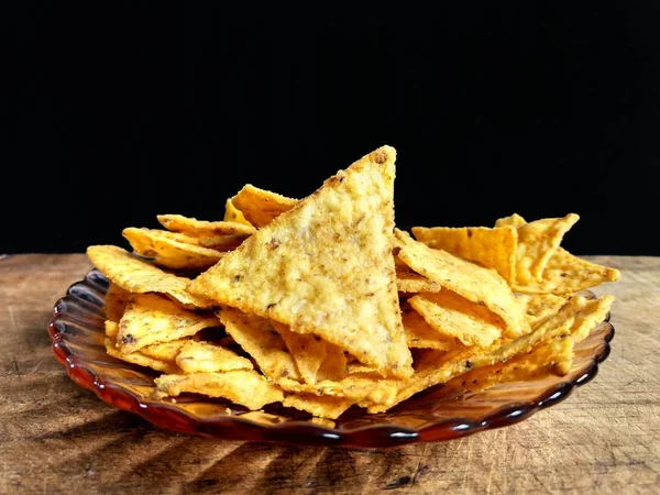 Nachos mit Käse auf Holzbrett mit schwarzem Hintergrund — Stockfoto