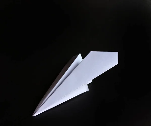 White paper plane on black background. funny concept — Stock Photo, Image