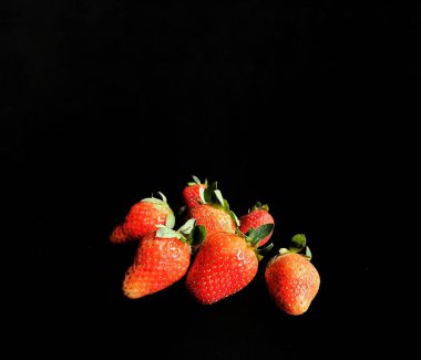 Siyah arka planda bir grup organik çilek. sağlıklı gıda konsepti