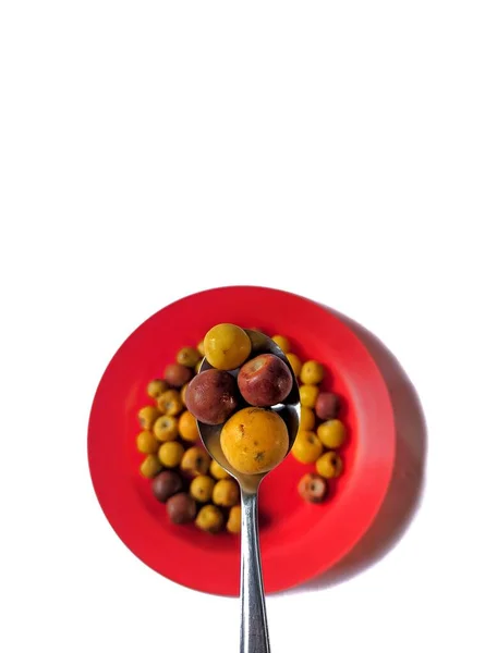 赤皿の上の黄色と茶色のニュアンスと白い背景のスプーン グアテマラの典型的な果物 — ストック写真